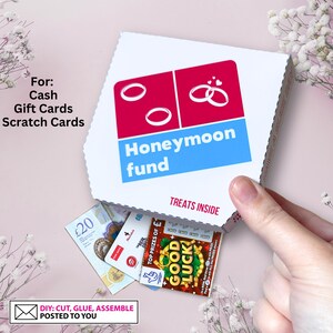 May include: A white box with a blue and red design that says "Honeymoon fund" and "Treats inside". The box is open and there are gift cards, scratch cards, and cash inside. The text "DIY: CUT, GLUE, ASSEMBLE POSTED TO YOU" is on a white envelope.