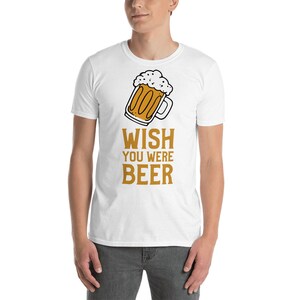 May include: White t-shirt with a cartoon drawing of a beer mug and the text "WISH YOU WERE BEER" in orange.