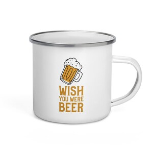 May include: White enamel camping mug with a silver rim and a handle. The mug features a cartoon image of a beer mug with the text "WISH YOU WERE BEER".