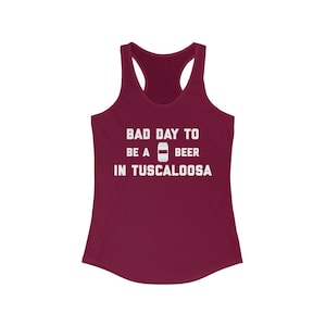 May include: A maroon tank top with the text "Bad Day To Be A Beer In Tuscaloosa" in white lettering. The text includes a graphic of a beer can.