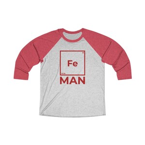 May include: A red and grey baseball tee shirt with a red square graphic featuring the chemical symbol for iron, Fe, and the word "MAN" below it.