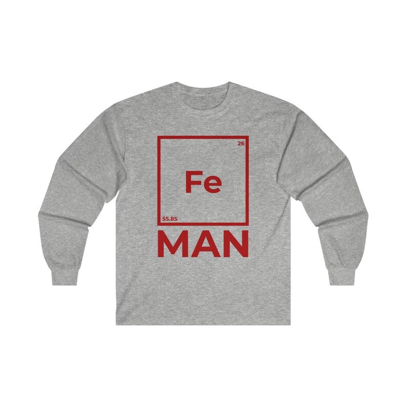 Puede incluir: Una camiseta de manga larga gris con un gr&aacute;fico cuadrado rojo que presenta el s&iacute;mbolo qu&iacute;mico "Fe" para el hierro, el n&uacute;mero at&oacute;mico "26" y el peso at&oacute;mico "55,85". El texto "MAN" est&aacute; impreso debajo del cuadrado.