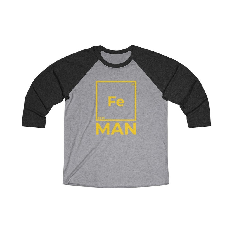 May include: A gray and black baseball tee shirt with a yellow graphic of the periodic table element iron, Fe, with the word "MAN" below it.