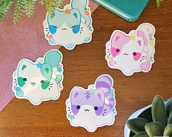 May include: Four colourful cat stickers with floral accents. Each sticker features a different coloured cat with a white face and closed eyes. The cats are in various poses, including sitting, lying down, and standing. The stickers are perfect for adding a touch of whimsy to laptops, water bottles, journals, and more.