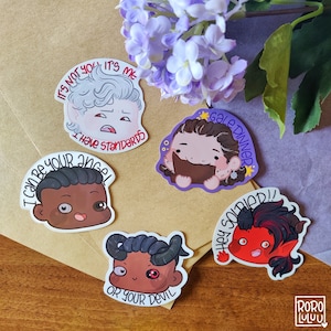 May include: Five colorful stickers with cartoon characters and text. The stickers feature a character with white hair and the text "It's not you, it's me. I have standards", a character with brown hair and the text "Gale Dinner", a character with brown skin and the text "I can be your angel or your devil", a character with brown skin and the text "Hey soldier!" and a character with red hair and the text "Gale Dinner".