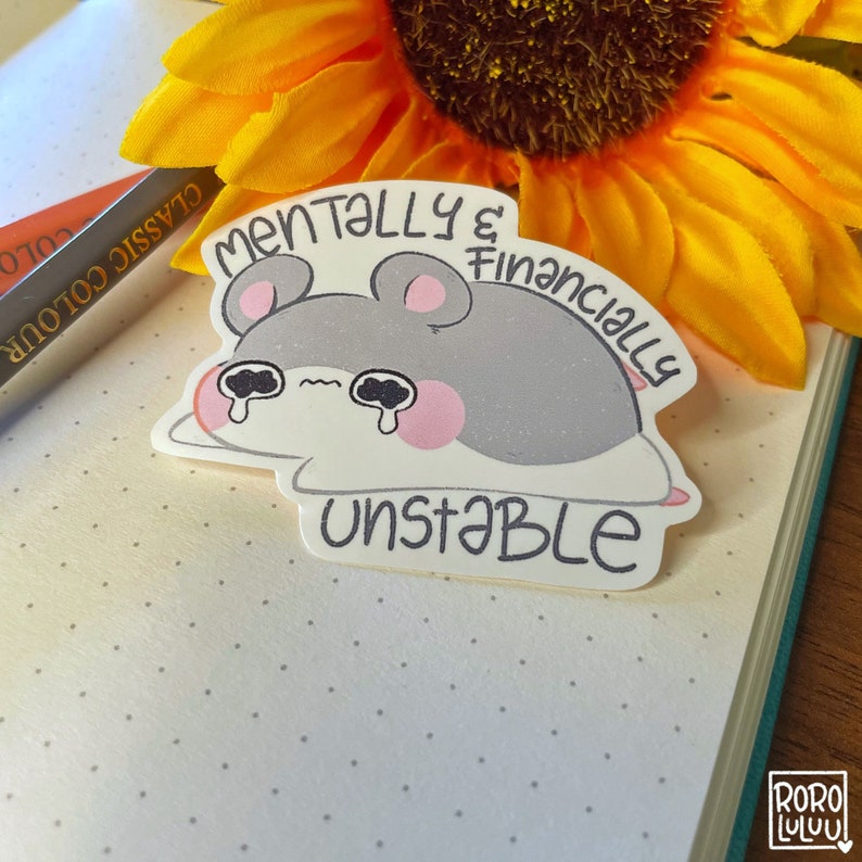 Op de afbeelding: Een sticker met een cartoon hamster met een droevige uitdrukking, die huilt. De sticker zegt "Mentally & Financially Unstable".