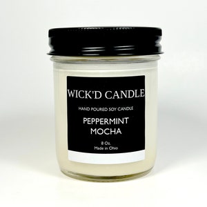 May include: A white candle in a clear glass jar with a black label that reads "Wick'd Candle", "Hand Poured Soy Candle", "Peppermint Mocha", "8 Oz", and "Made in Ohio".