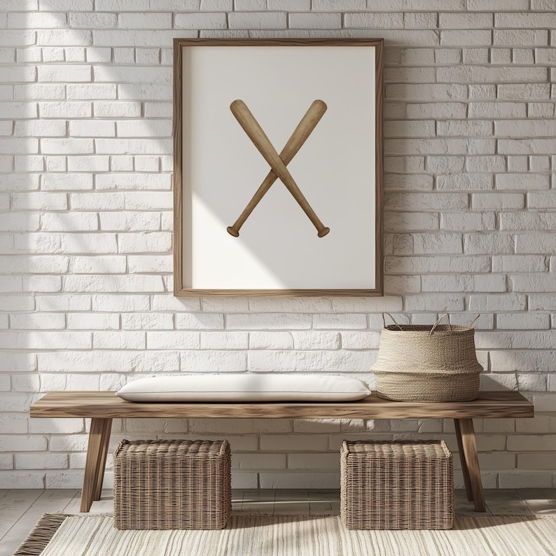 May include: A framed print featuring two crossed baseball bats in a minimalist style. The bats are a light brown color, set against a white background. The frame is a warm brown, and the artwork hangs above a wooden bench.