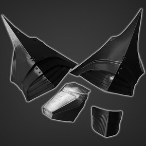 Puede incluir: Un conjunto de cinco piezas de casco impresas en 3D en negro. Las piezas tienen forma de casco con una parte superior puntiaguda y una parte inferior curva. Las piezas est&aacute;n dise&ntilde;adas para ensamblarse y crear un casco completo.
