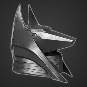 Puede incluir: Un casco de pl&aacute;stico negro impreso en 3D, inspirado en Anubis, con un dise&ntilde;o angular y puntiagudo. El casco tiene un hocico puntiagudo y alargado y un collar texturizado detallado.