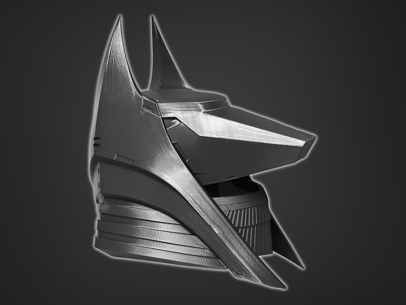 Puede incluir: Un casco de pl&aacute;stico negro impreso en 3D, inspirado en Anubis, con un dise&ntilde;o angular y puntiagudo. El casco tiene un hocico puntiagudo y alargado y un collar texturizado detallado.