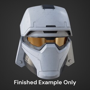 May include: A white helmet with a black visor and a textured surface. The helmet has a gold-colored visor and a black trim around the edges.