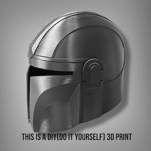 Puede incluir: Un casco negro y gris impreso en 3D, con visera y parte superior redondeada. El texto "THIS IS A DIY(DO IT YOURSELF) 3D PRINT" est&aacute; en la parte inferior. El casco tiene apariencia met&aacute;lica, probablemente un accesorio o disfraz.