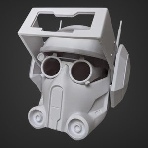 May include: A white 3D printed helmet with a visor and goggles. The helmet has a futuristic design with multiple details and a textured surface.