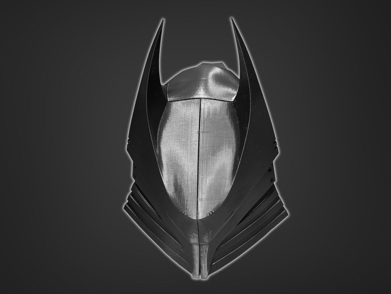 Puede incluir: Un casco de pl&aacute;stico negro con un dise&ntilde;o puntiagudo y angular. El casco tiene una superficie texturizada y una serie de crestas a los lados.