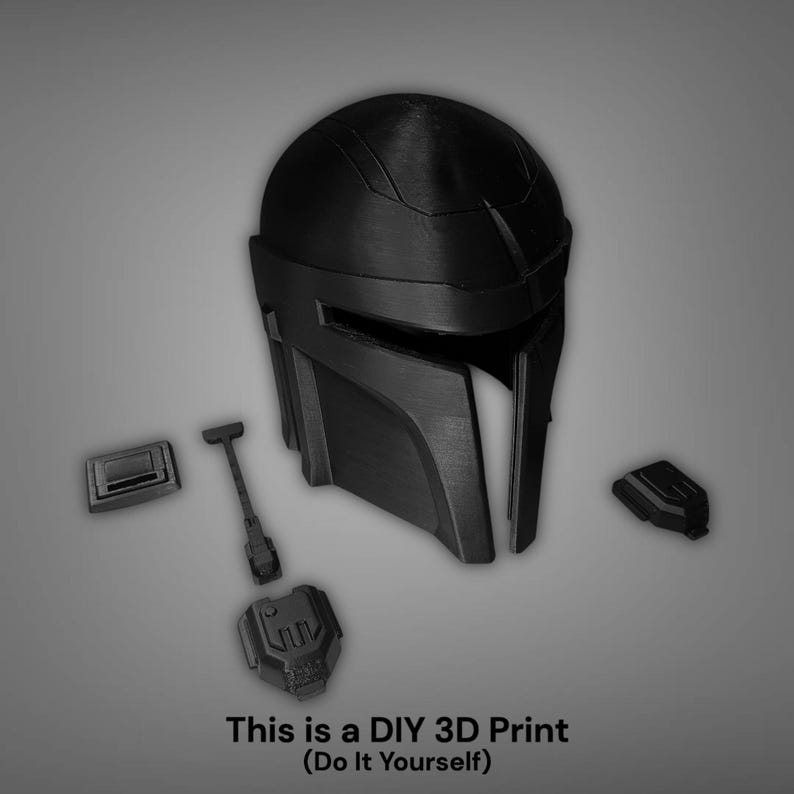 Puede incluir: Casco mandaloriano negro impreso en 3D con componentes separados. El casco presenta una visera en forma de T y un dise&ntilde;o angular. El texto en la parte inferior dice: "This is a DIY 3D Print (Do It Yourself)".