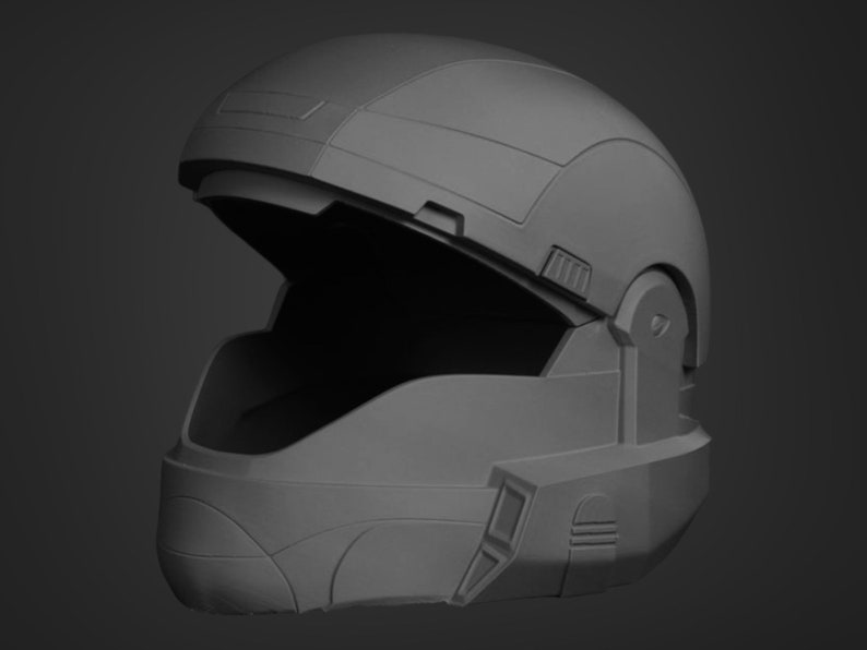 Puede incluir: Un casco gris futurista con una visera abierta. El casco tiene una superficie texturizada y varios detalles.