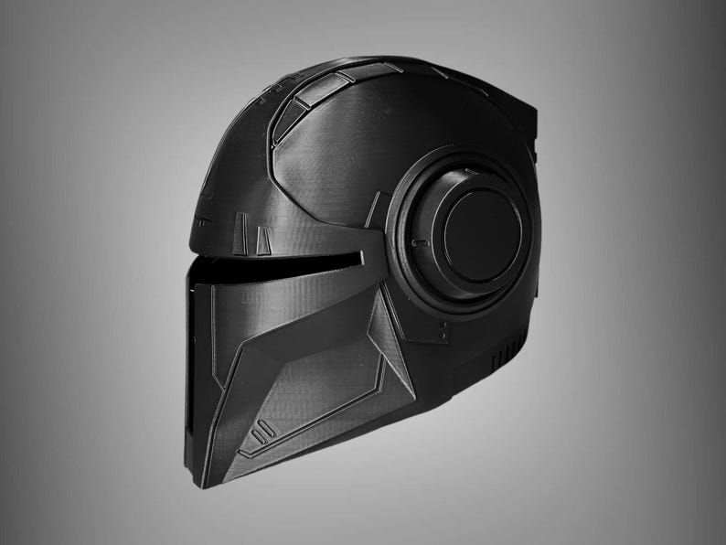 May include: A black helmet with a futuristic design. The helmet has a visor and a large, round, black detail on the side.