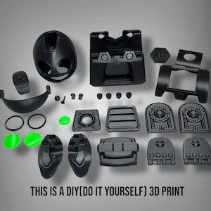 May include: Black 3D printed parts arranged on a gray surface. The components include a rounded helmet-like piece, various panels, and small circular and oval pieces. The text "THIS IS A DIY(DO IT YOURSELF) 3D PRINT" is at the bottom.