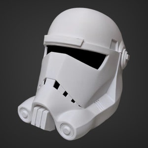 May include: A white plastic helmet with a black visor and a detailed design. The helmet has a rounded top and a pointed chin.