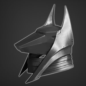 Puede incluir: Un casco negro y plateado con un dise&ntilde;o puntiagudo y angular. El casco tiene una forma alargada distintiva con una parte superior puntiaguda y una l&iacute;nea de la mand&iacute;bula afilada y angular.