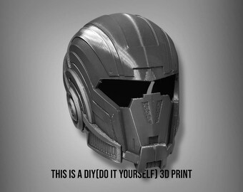 May include: A 3D printed helmet with a futuristic design. The helmet is gray and has a visor that covers the eyes. The helmet is a DIY project, as indicated by the text "THIS IS A DIY (DO IT YOURSELF) 3D PRINT" at the bottom of the image.