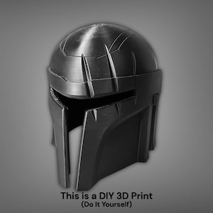 Puede incluir: Un casco negro impreso en 3D con un dise&ntilde;o detallado, con una parte superior redondeada y una visera angular. La imagen incluye el texto "This is a DIY 3D Print (Do It Yourself)". El casco parece ser un accesorio o una pieza de vestuario.