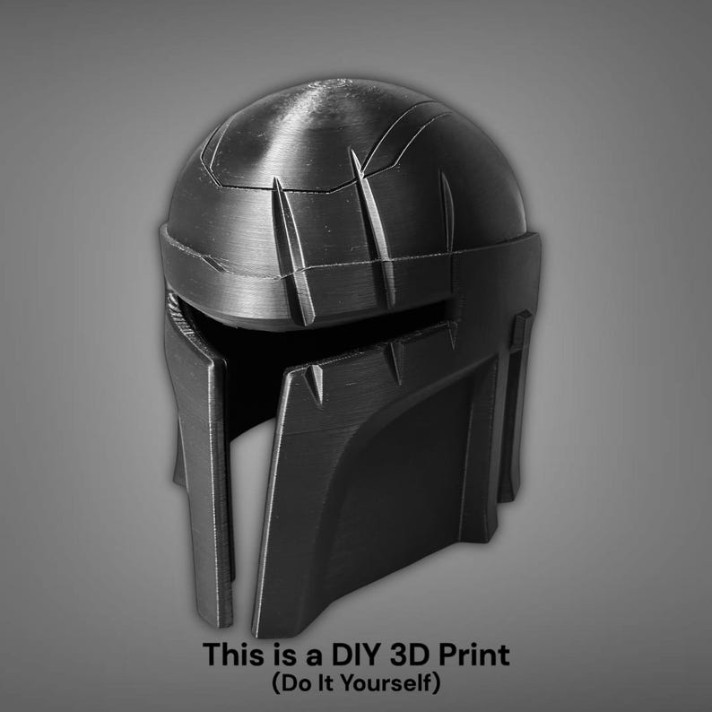 Puede incluir: Un casco negro impreso en 3D con un dise&ntilde;o detallado, con una parte superior redondeada y una visera angular. La imagen incluye el texto "This is a DIY 3D Print (Do It Yourself)". El casco parece ser un accesorio o una pieza de vestuario.