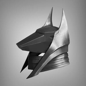 Puede incluir: Un casco negro y plateado con un dise&ntilde;o puntiagudo y angular. El casco tiene una nariz larga y puntiaguda y dos orejas altas y puntiagudas.