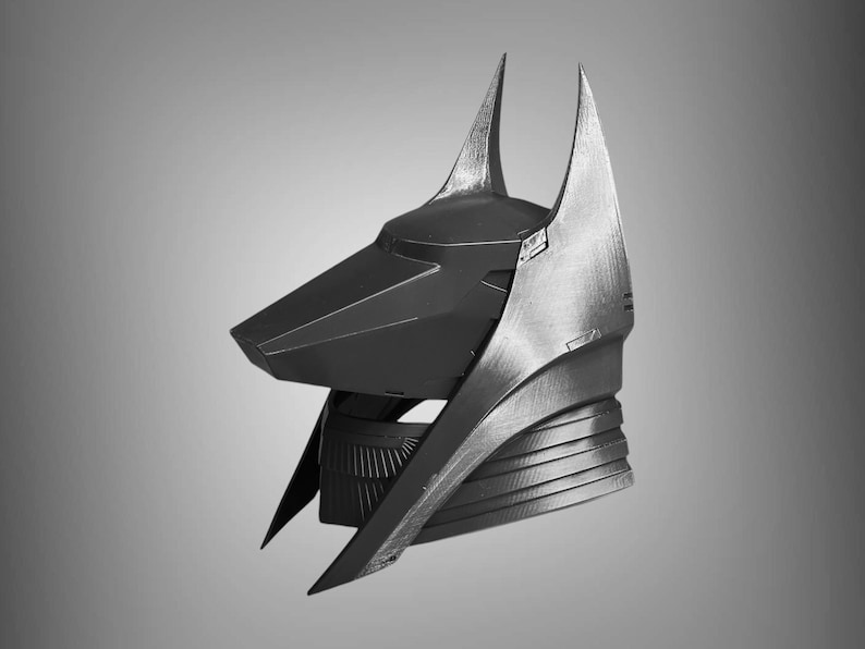 Puede incluir: Un casco negro y plateado con un dise&ntilde;o puntiagudo y angular. El casco tiene una nariz larga y puntiaguda y dos orejas altas y puntiagudas.