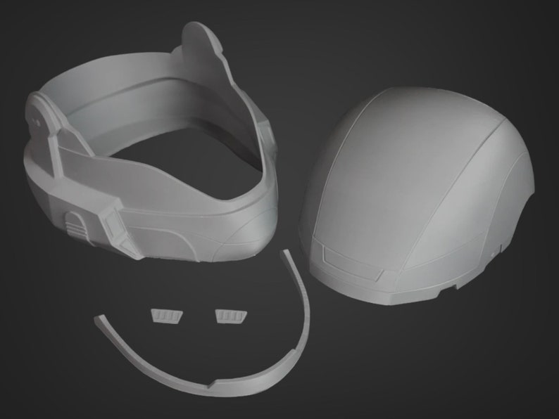 Puede incluir: Un casco de pl&aacute;stico gris con m&uacute;ltiples piezas, incluyendo una parte superior, una inferior y una visera. El casco est&aacute; dise&ntilde;ado para ser ensamblado.