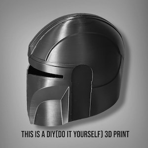 Puede incluir: Un casco negro y gris impreso en 3D con visera y superficie detallada. El texto "THIS IS A DIY(DO IT YOURSELF) 3D PRINT" est&aacute; en la parte inferior. El casco es probablemente para cosplay o exhibici&oacute;n.