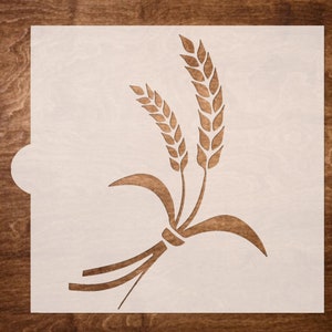 May include: A white stencil with a design of wheat stalks. The stencil is made of a thin, flexible material and is designed for use with paint or other mediums.