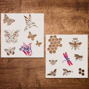 May include: Two white stencil sheets with various insect designs. The first sheet features butterflies, a hummingbird, and a dragonfly. The second sheet features bees, a honeycomb, and a dragonfly.