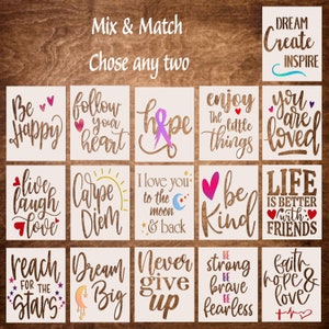 May include: A set of 16 stencils with inspirational quotes and designs. The stencils are white and feature phrases like "Be Happy", "Follow Your Heart", "Hope", "Enjoy The Little Things", "You Are Loved", "Live Laugh Love", "Carpe Diem", "I Love You To The Moon And Back", "Be Kind", "Life Is Better With Friends", "Reach For The Stars", "Dream Big", "Never Give Up", "Be Strong Be Brave Be Fearless", "Faith Hope & Love".