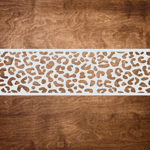 May include: White stencil featuring a leopard print design. The stencil is made from a thin, flexible material and is ideal for creating a range of crafts.
