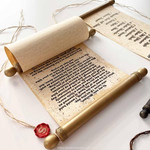 Op de afbeelding: Een decoratieve rol met een beige, verouderd papieruiterlijk met zwarte gedrukte tekst gericht aan een zoon genaamd Michael. De rol is bevestigd aan twee goudkleurige houten staven met afgeronde uiteinden en bevat een rood waszegel met een S.