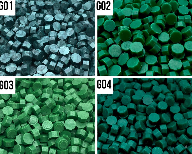 May include: Four different shades of green sealing wax. The wax is in the shape of small, round pellets. The colors are teal, forest green, dark green, and a lighter shade of green.