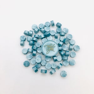May include: A pile of blue wax seals with a single wax seal with the words "Thank You" in gold lettering.