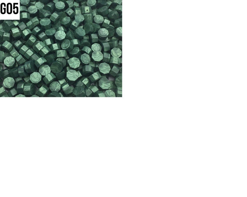 May include: A close-up image of a large quantity of dark green wax seal beads. The beads are hexagonal in shape and have a slightly textured surface.