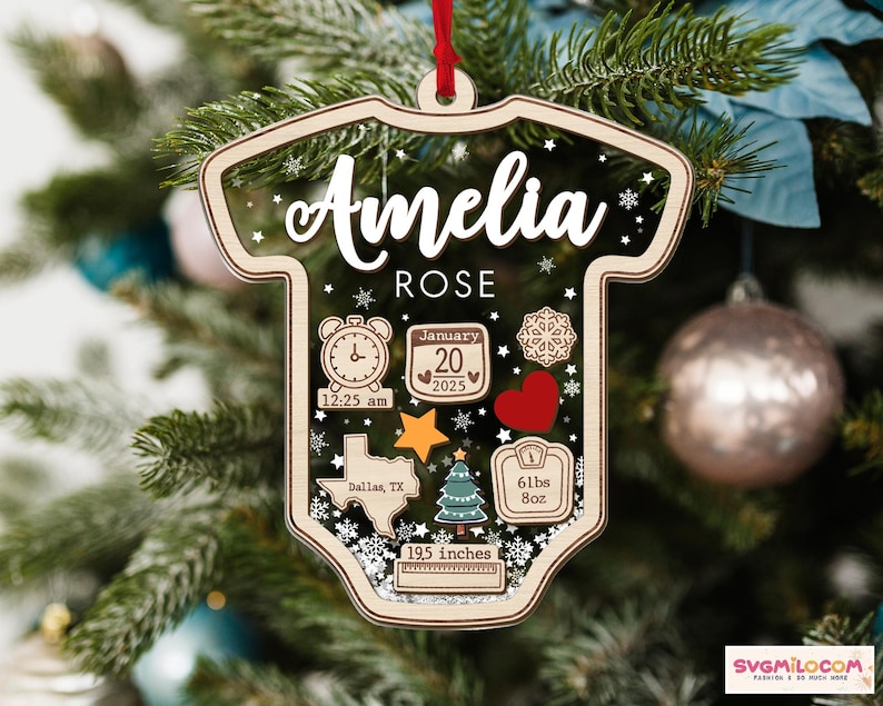 May include: A clear, onesie-shaped acrylic ornament with a wooden border and red ribbon. It features the name Amelia Rose, a clock showing 12:25 am, a calendar for January 20, 2025, a Texas map, a Christmas tree, a heart, and a scale reading 6lbs 8oz.