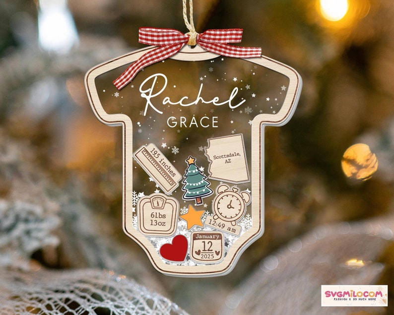 May include: A clear, onesie-shaped acrylic ornament with a red and white gingham ribbon. It features the name Rachel Grace, a ruler labeled 195 inches, a map of Arizona, a Christmas tree, a scale reading 61lbs 13oz, a clock at 12:49 am, and a calendar date of January 12, 2025.