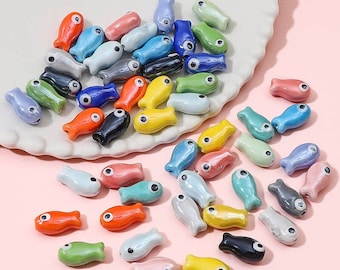 Conjunto de 10 contas de cerâmica coloridas em formato de peixe, ideais para artesanato e confecção de bijuterias.