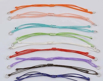 May include: A set of ten colorful cord bracelets with silver metal clasps. The cords are in the colors orange, peach, turquoise, light green, white, red, purple, brown, and dark blue.