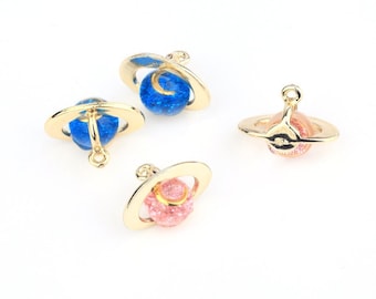 May include: Four gold-toned charms shaped like planets with glitter embedded in the blue and pink spheres. The charms have a loop at the top for attaching to jewelry.