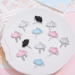 May include: Assortment of 12 cloud charms in various colors, including pink, blue, white, and black. Each charm features a silver metal cloud with a lightning bolt or raindrops.