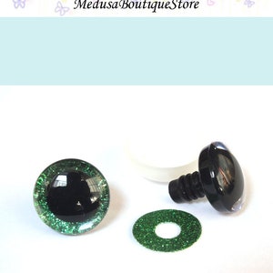 May include: A set of green glitter safety eyes for stuffed animals. The set includes two eyes, a washer, and a plastic back. The eyes are 12mm in diameter.