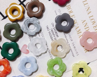 Peut inclure: Assortiment de 12 breloques en résine de forme florale colorées avec un trou au centre. Les breloques sont de différentes couleurs, notamment rose, jaune, vert, bleu et blanc. Certaines breloques ont un effet marbré.