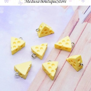 Peut inclure: Six pendentifs en forme de fromage jaune avec des anneaux de saut argentés. Les breloques sont en forme de morceau de fromage avec des trous.