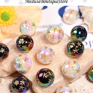 May include: Iridescent glass beads with gold star patterns. The beads have a pearlescent finish, reflecting a spectrum of colors. The image includes the text "Medusa Boutique Store". These beads are suitable for jewelry making and crafts.